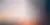 Silhouette of person with headphones looking at a computer screen with a bright sunset behind them
