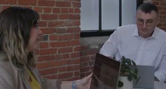 Two people discussing a project on their laptops.