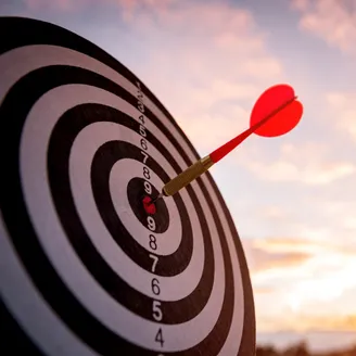 Dart hitting a bulseye on a dartboard